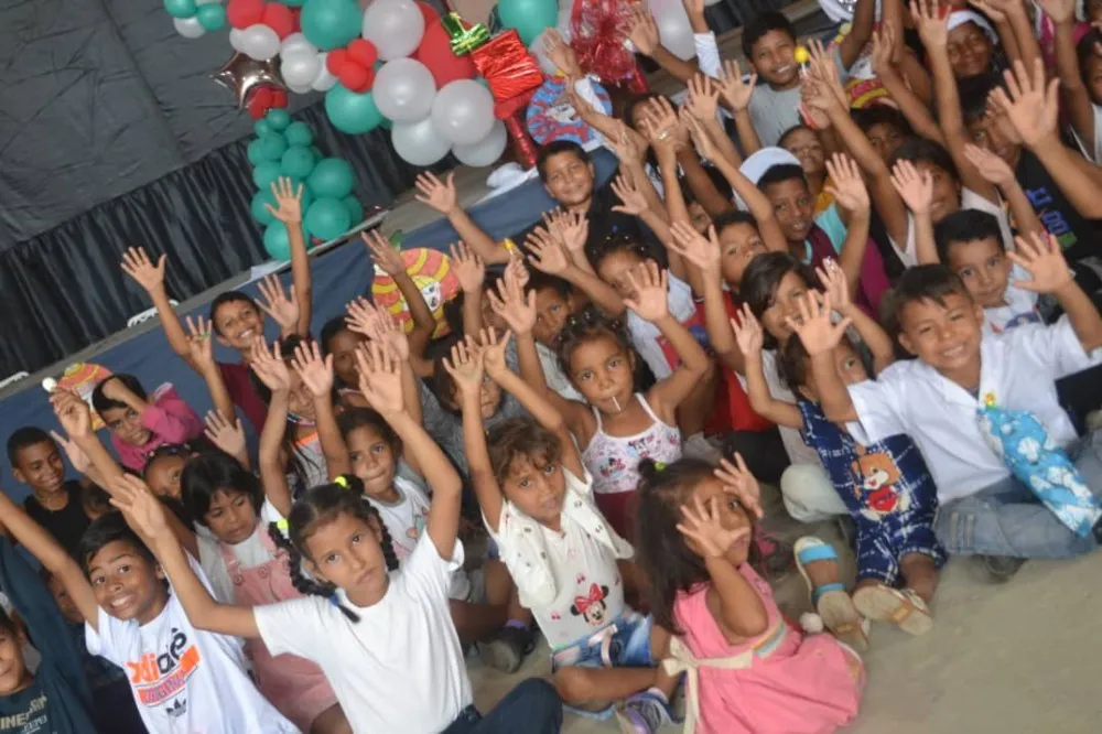 Niños con las manos en alto en la celebración de Navidad de 2022.
