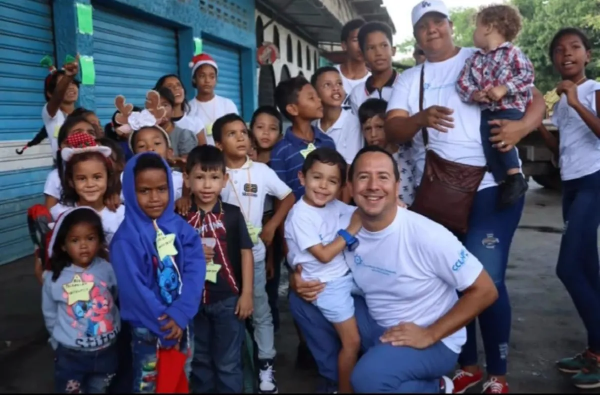 Randy Lander kneeling with a group of children and volunteers in Venezuela.